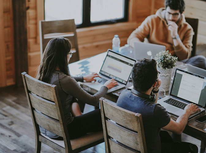 Team arbeitet gemeinsam an Laptops in einer modernen Arbeitsumgebung