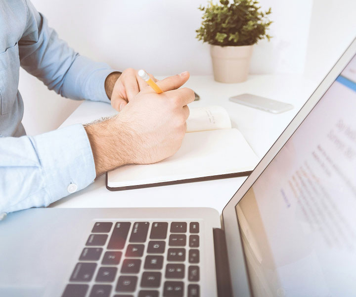 Mitarbeiter macht Notizen am Laptop