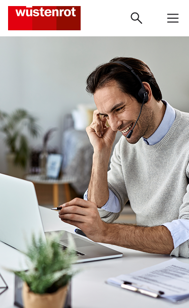 Berater mit Headset am Laptop während einer Videoberatung